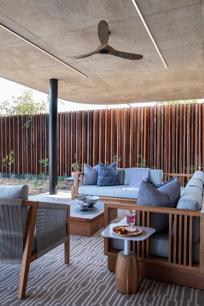 Three-blade timber ceiling fan over a covered outdoor lounge